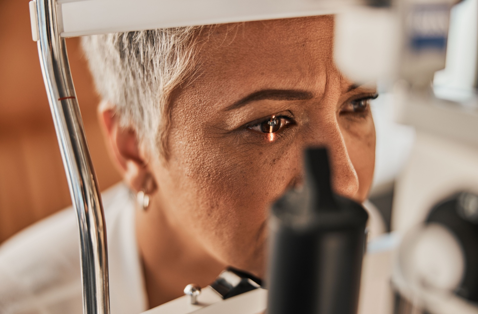 A patient's ocular health is assessed using a slit lamp during their routine eye exam.